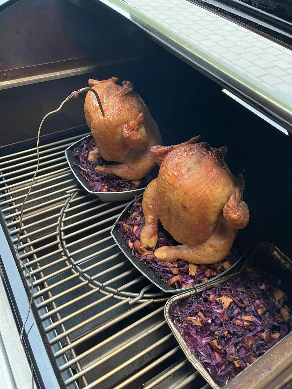 Foto z Weber grilovací akademie. Pohled na připravená kuřata na stojáncích Weber Delux na plynovém grilu.